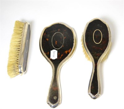 Lot 83 - A silver and tortoiseshell backed three piece dressing table set comprising mirror and two brushes