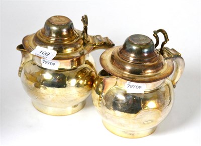 Lot 109 - A pair of George III Old Sheffield silver plated tankards, the covers set with coins