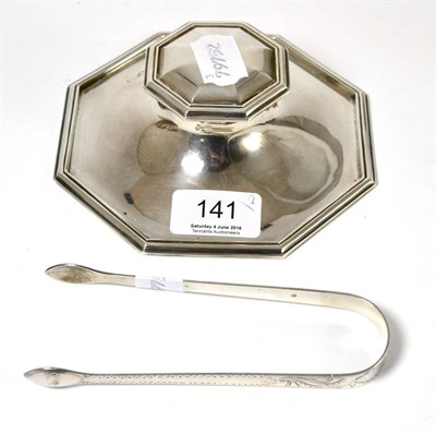 Lot 141 - A silver inkwell and a pair of George III silver sugar tongs with bright cut decoration