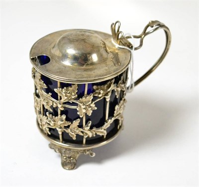 Lot 475 - A Victorian silver mustard with decorative leaf design and blue glass liner