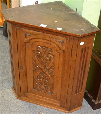 Lot 1193 - A carved oak hanging corner cupboard