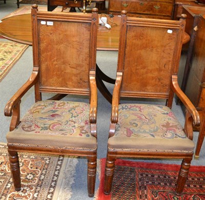 Lot 1224 - A pair of carved oak hall chairs with panelled backs