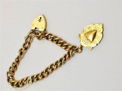 Lot 79 - A curb and lock bracelet hung with a shield