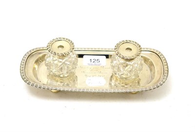 Lot 125 - A silver twin inkwell raised on four ball feet, engraved