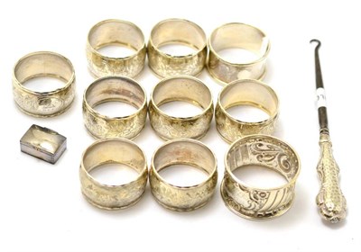 Lot 406 - A silver button hook, a set of eight silver napkin rings, two other odd silver napkin rings and...