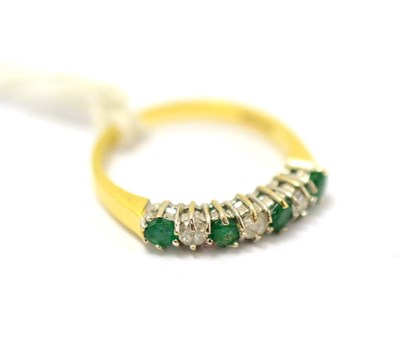 Lot 411 - An emerald and diamond half hoop ring