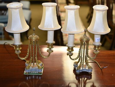 Lot 528 - A pair of gilt metal table lamps, decorated with swags and scrolls on dolphin form feet and...