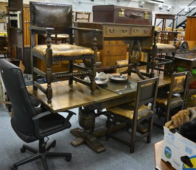 Lot 1029 - A 1920's oak draw leaf dining table with trestle base and a set of six chairs with studded...