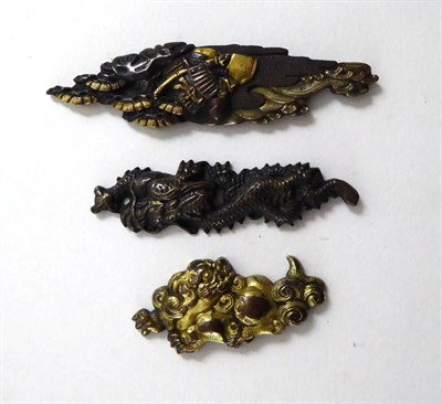 Lot 139 - Three Japanese Meiji period gilt metal mounts in the form of a dragon, a pig and samurai...