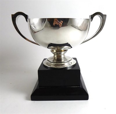 Lot 329 - A silver two handled trophy cup on ebonised stand, bearing presentation plaque