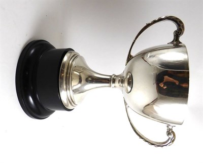 Lot 330 - A silver two handled trophy cup on ebonised stand