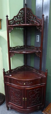 Lot 1253 - A Chinese hardwood free-standing corner cabinet with graduated shelves