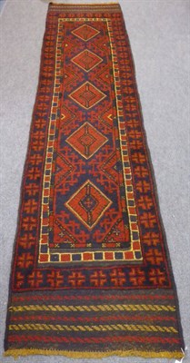 Lot 1279 - A narrow Afghan Balouch runner, the field with a row of diamond medallions enclosed by...