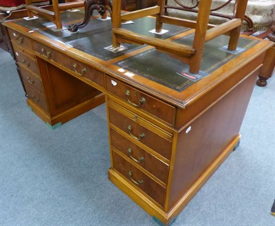 Lot 1325 - A 20th century leather inset pedestal desk, the main banks of drawers opposed by dummies