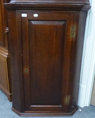 Lot 1344 - A George III oak hanging corner cupboard