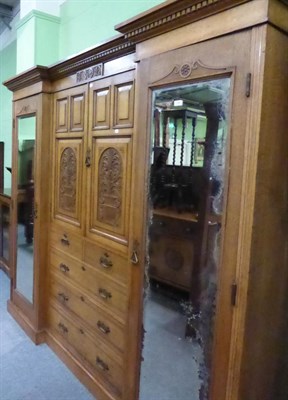 Lot 1346 - An early 20th century inverted breakfront, carved panel and mirror fronted oak triple wardrobe