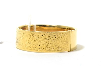 Lot 81 - A 9ct gold half engraved hinged bangle