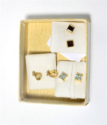 Lot 92 - A pair of 9ct gold garnet stud earrings, a pair of 9ct gold blue topaz stud earrings and a pair...