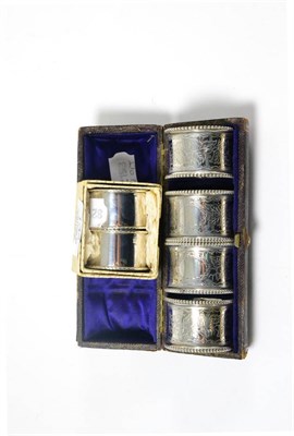 Lot 134 - A cased set of four Victorian silver napkin rings and another later pair, boxed