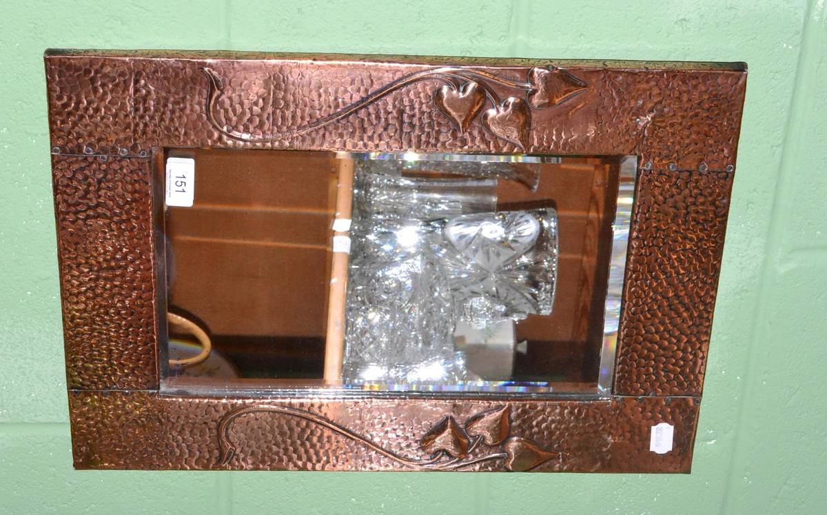 Lot 151 - A Liberty style Art Nouveau copper wall mirror with repousse frame