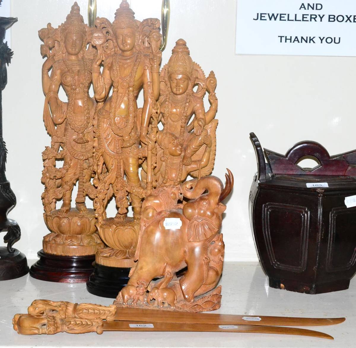 Lot 162 - Three large Indian sandalwood deity figures, another figure group modelled as elephants and...