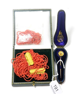 Lot 191 - A knot pin, in a fitted case, two coral bracelets and some coral requiring a re-string