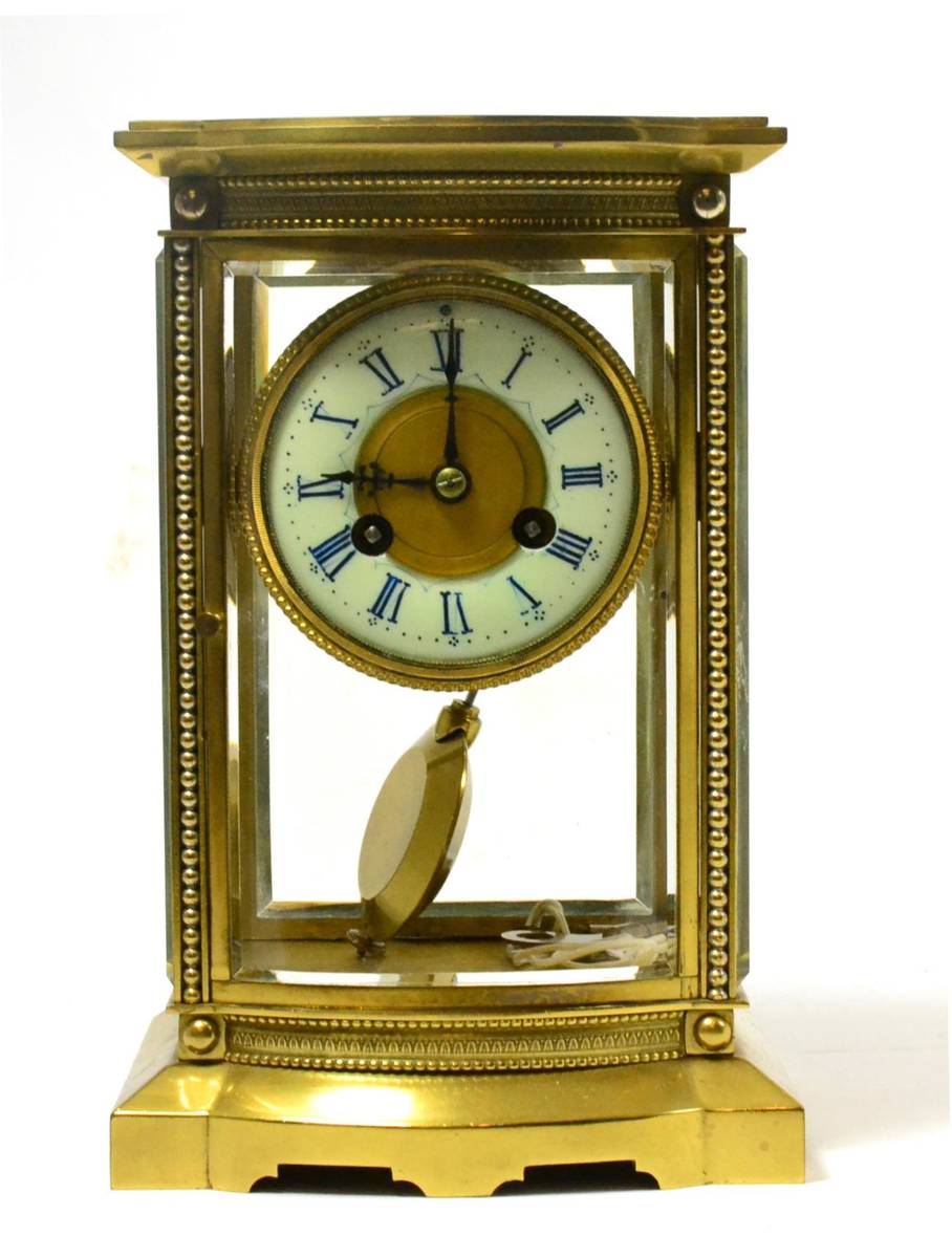 Lot 267 - A brass four glass striking mantle clock with bowed front panel, the movement signed