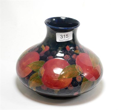 Lot 315 - A William Moorcroft Pomegranate pattern vase, on a blue ground, impressed factory marks, green...