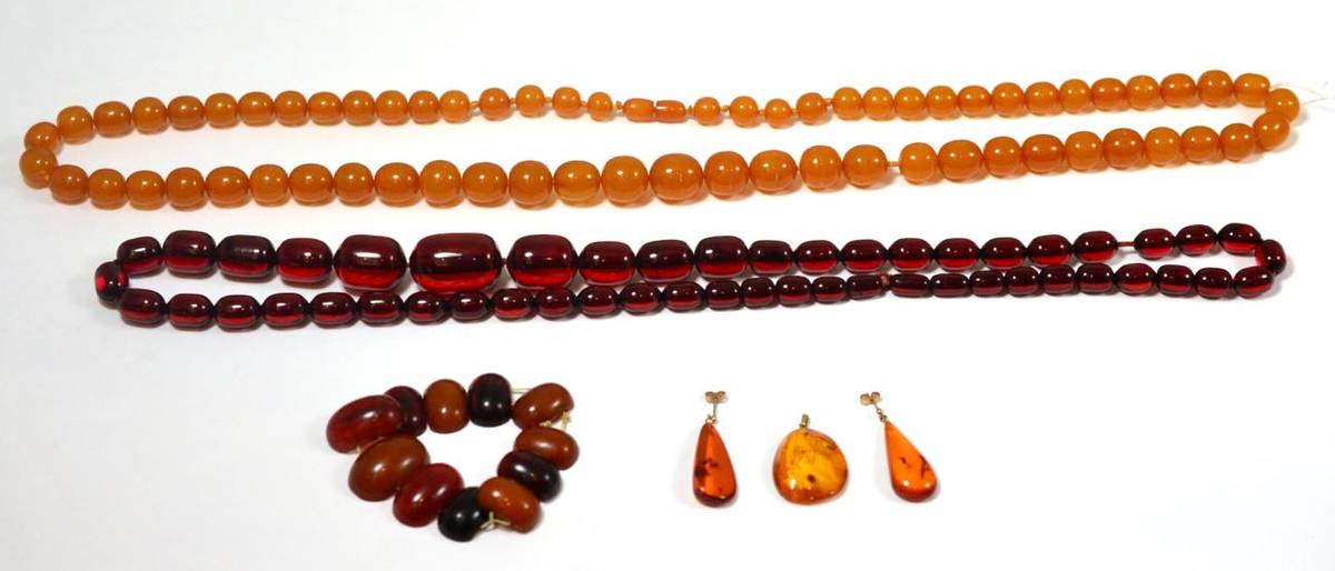 Lot 374 - An amber bead necklace, a red bead necklace, a pair of amber drop earrings, an amber pendant...