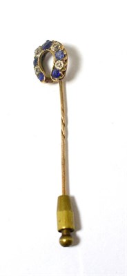 Lot 428 - An old cut diamond and sapphire horseshoe stickpin, total estimated diamond weight 0.45 carat...