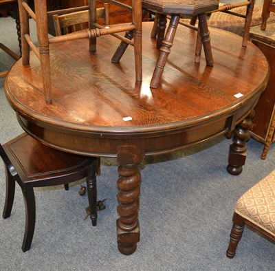 Lot 1066 - An early 20th century oak wind out dining table (lacking leaf)