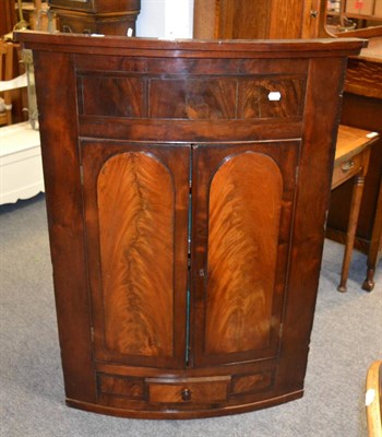 Lot 1072 - A bow fronted corner cupboard