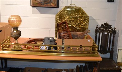 Lot 1104 - A group including a brass fender, fire screen, reproduction ships wheel, oil lamp, cased...