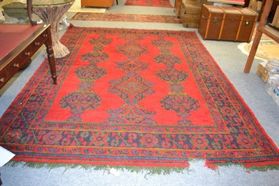 Lot 1175 - Ushak carpet, Central Anatolia, the tomato red field with three rows of guls enclosed by...