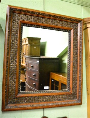 Lot 1290 - An oak wall mirror carved with trellis and leaf design