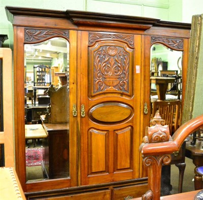 Lot 1294 - A large carved mahogany mirror fronted triple wardrobe