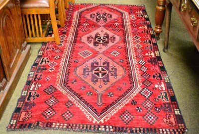 Lot 1308 - A Kashgai rug, South West Iran, the strawberry lozenge field with three diamond medallions enclosed