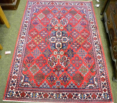 Lot 1309 - A Joshaghan rug, Central Iran, the blood red lattice field with central medallion enclosed by...