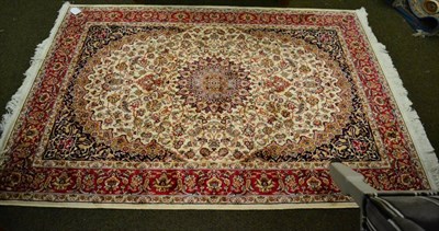 Lot 1359 - An artificial silk rug of Persian design, the cream field of scrolling vines around a pole...