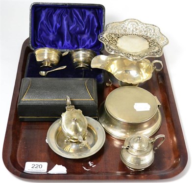 Lot 220 - A silver basket, inkwell, sauceboat, two mustards, armada dishes, cased salts and cased napkin...