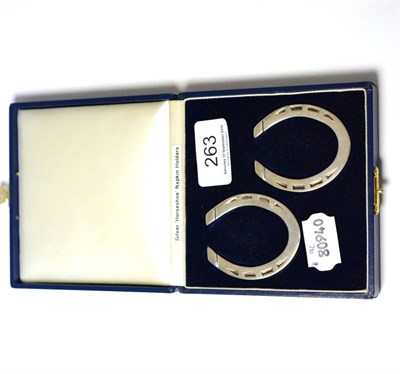 Lot 263 - A pair of silver horseshoe napkin rings, cased