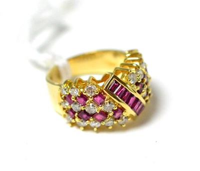 Lot 314 - ~A ruby and diamond ring, a broad cluster with a row of baguette cut rubies channel set...