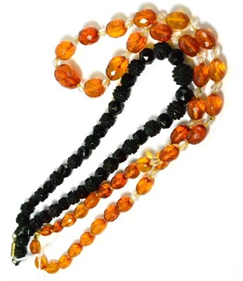 Lot 393 - A faceted and carved jet necklace and a faceted amber and paste necklace