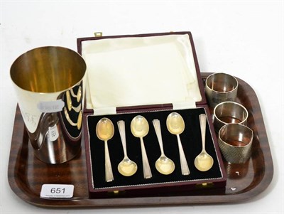 Lot 651 - Silver wares comprising: a beaker, three napkin rings and a cased set of spoons