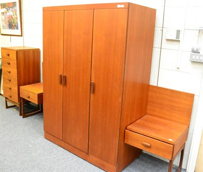 Lot 1142 - A G Plan teak bedroom suite comprising: double bed head with integral bedsides, wardrobe and...