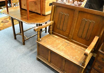 Lot 1153 - A linen fold carved box settle and an oak drop leaf table