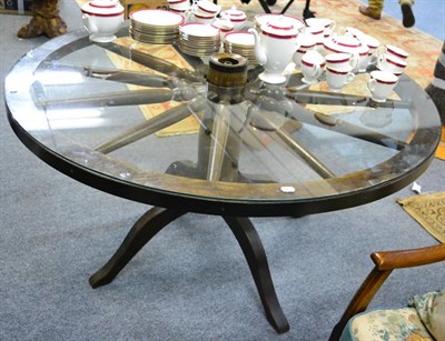 Lot 1216 - An oak cartwheel dining table with glass top