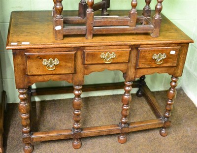 Lot 1315 - An oak side table fitted with three frieze drawers and raised on turned legs joined by stretchers