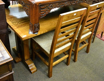 Lot 1351 - A mango wood table with trestle base and four ropework ladder back chairs