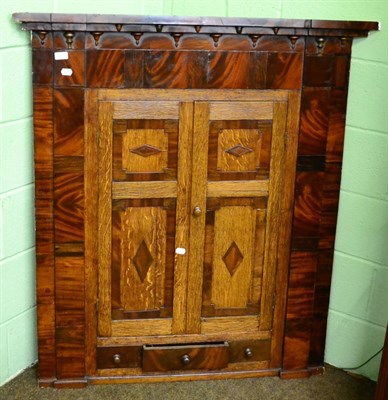 Lot 1416 - A good George III oak and mahogany panelled hanging corner cupboard fitted with drawers